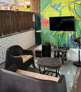 a living room with chairs and a tv and a table at D Bamboo House in Mabini