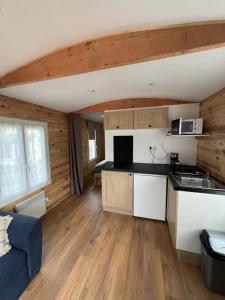 a kitchen and living room in a log cabin at La Roulotte des Gaillots in Moiremont