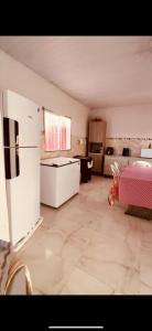 a large room with a kitchen with a refrigerator at Casa de veraneio jacuma in Conde