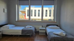 two beds in a room with a window at Valmiera Park Hostel in Valmiera +14 photos