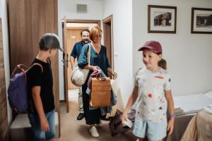 a family walking into a hotel room with luggage at Šport Hotel *** Donovaly in Donovaly +88 photos
