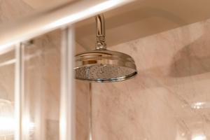 a shower in a bathroom with a shower head at Great Ashley Farm Holiday Cottage & Shepherds Huts in Bradford on Avon +102 photos