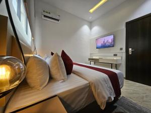 a bedroom with a bed with a television on the wall at Teestone Hotels and Apartment Ikeja in Lagos