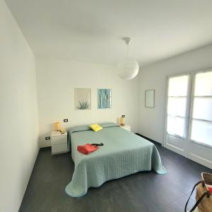 a white bedroom with a bed and a window at Al Molino delle Ghiare in Levanto