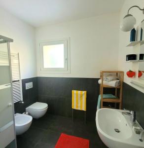 a bathroom with two sinks and a toilet and a window at Al Molino delle Ghiare in Levanto