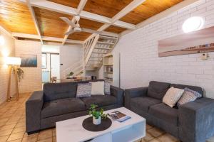 a living room with two couches and a table at Reef Villa- Kalbarri Central with Pool in Kalbarri