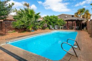 a swimming pool with blue water in a yard at Reef Villa- Kalbarri Central with Pool in Kalbarri