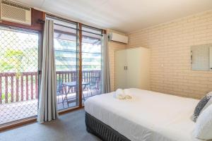 a bedroom with a bed and a balcony at Reef Villa- Kalbarri Central with Pool in Kalbarri +10 photos