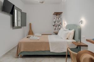 a bedroom with a bed with a green chair at Luaz Naxian living in Naxos Chora