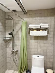 a bathroom with a shower with a toilet and towels at 34 Silver Rooms in Tbilisi City +65 photos