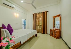 a bedroom with a bed and a dresser and a mirror at Ahungalla Ocean Villa in Ahungalla +8 photos