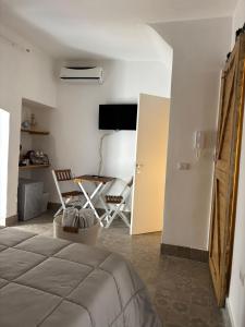 a bedroom with a bed and a table and a chair at Dioniso Affittacamere in Conversano