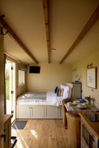 a room with a bed in the corner of a room at Great Ashley Farm Holiday Cottage & Shepherds Huts in Bradford on Avon