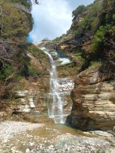 a waterfall on the side of a rocky cliff at Archontiko Michael Pelion in Vyzitsa