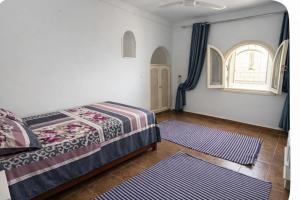 a bedroom with a bed and a window and two rugs at Beach Family Villa - Private Pool - Sea view - Up to 14 guests- only 40 Meters to the Beach! in Alexandria
