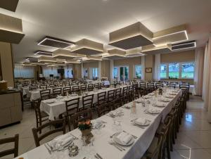 a banquet hall with long tables and chairs at Hotel Ristorante Sasso Remenno in Val Masino +33 photos