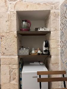 a shelf above a refrigerator in a brick wall at Dioniso Affittacamere in Conversano