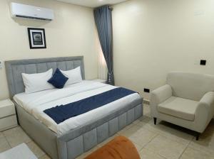 a bedroom with a bed and a chair at Captain Residency Hotel in Lagos +58 photos