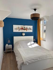 a bedroom with a blue accent wall and a bed at Le Grand Bleu in Troyes