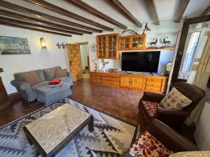 a living room with a couch and a tv at Casa El Carril Vinuesa in Vinuesa