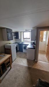 a kitchen with blue cabinets and a table in it at Penbryn Holidays No 2 in Barmouth