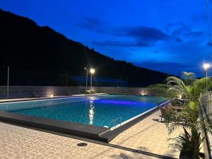 a swimming pool at night with the lights on at Glamping&Port結 in Shimada