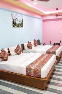 a couple of beds in a room at Hotel Dipak in Himatnagar