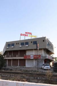 a building with a sign on it next to a train tracks at Hotel Dipak in Himatnagar