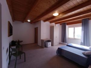 ein Schlafzimmer mit Bett, Schreibtisch und Fenster in der Unterkunft Riama in Torralba