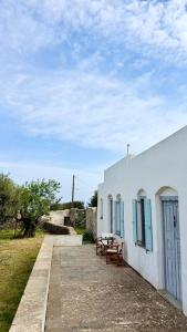 a white building with a table and benches next to it at Captains Garden House in Katavatí