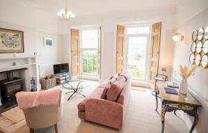 a living room with a pink couch and a fireplace at Old Vicarage Mortehoe Near Woolacombe 2 x sleeps 4 and 1 x sleeps 10 cottages in Mortehoe