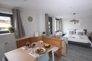 a room with a bed and a table with food on it at L'Impasse en Duo, appartement cosy 2 personnes avec SPA extérieur privé in Munster