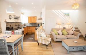 a living room with a couch and a table at Old Vicarage Mortehoe Near Woolacombe 2 x sleeps 4 and 1 x sleeps 10 cottages in Mortehoe