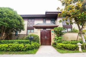 a house with a wooden door and a sidewalk at Book and Bed-ChongMing in Shanghai