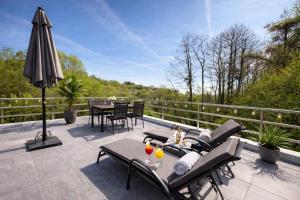 a patio with a table and chairs and an umbrella at Im Wald in Gleiszellen-Gleishorbach