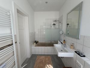 a bathroom with a sink and a bath tub at Stadtpalais Belle Etage - historische Villa nahe Theater und Soletherme in Bad Elster +31 photos
