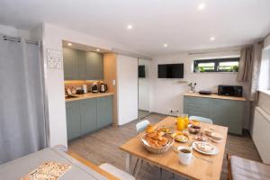 a kitchen and dining room with a table with food on it at L'Impasse en Duo, appartement cosy 2 personnes avec SPA extérieur privé in Munster +1 photo
