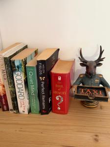a shelf with books and a statue of a reindeer at The Dairyman Suite in Dorchester