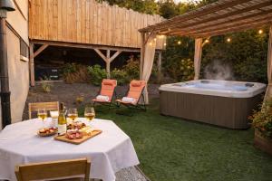 a table with a plate of food and a hot tub at L'Impasse en Duo, appartement cosy 2 personnes avec SPA extérieur privé in Munster