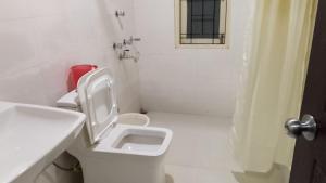 a white bathroom with a toilet and a shower at Hotel DR Retreat in Pakhyong