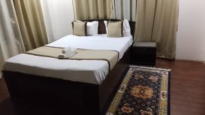 two beds in a hotel room with a rug at Hotel DR Retreat in Pakhyong