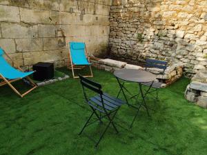 three chairs and a table and a table and chairs at la bulle d'Edward gare jardin centre in Angoulême