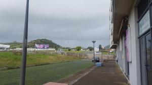 una calle fuera de un edificio con un coche en la carretera en Apartamento Vista Deslumbrante en Ponta Delgada