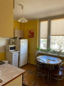 a kitchen with a white refrigerator and a table at Apartament przy górce in Biała Podlaska