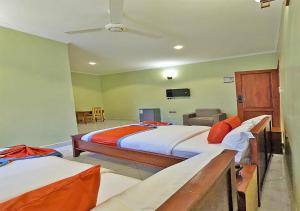 a bedroom with two beds and a tv on the wall at Salpat Camp Lodge in Moshi +25 photos