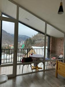 a room with a balcony with a view of a mountain at ksenia apartment in Borjomi +5 photos