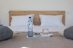 a bottle of water and a plate of food on a bed at Cerro da Campaniça in Santiago do Cacém