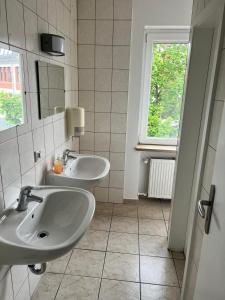 a bathroom with two sinks and a window at Pension Baron in Fürth +19 photos
