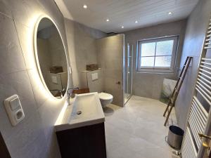 a bathroom with a sink and a toilet and a mirror at Bernstein-Chalet unten in Hohwacht +16 photos