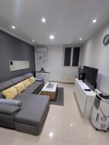a living room with a couch and a tv at Apartment Alex in Rijeka